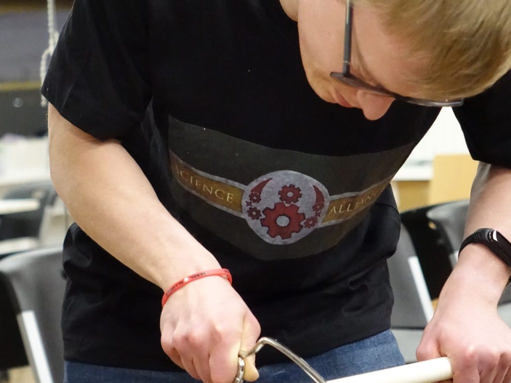 Image of young man using a hand saw