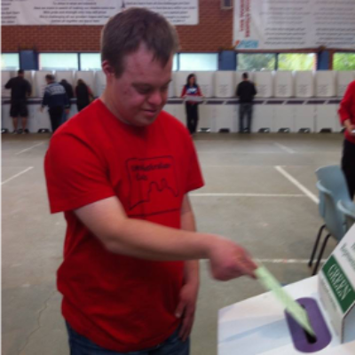 A man places a voting paper into a box
