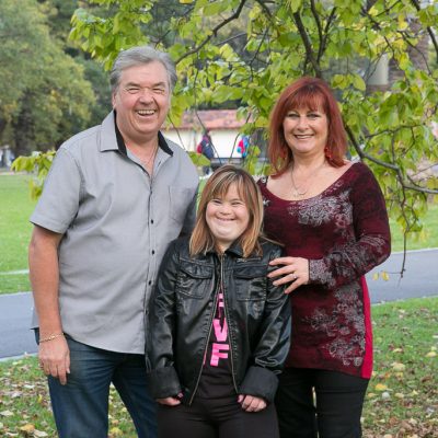 A mother, father and daughter stand together outdoors