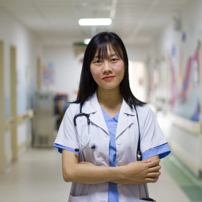 A nurse stands in the corridor of a hospital