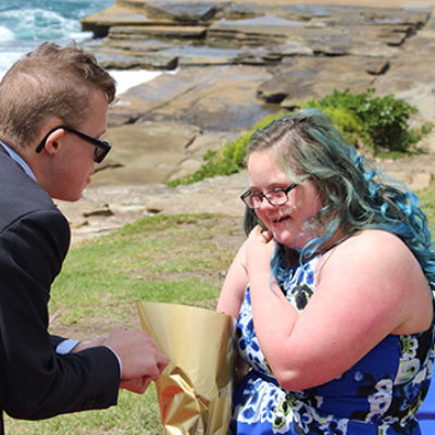 A young man proposes to a young woman outdoors