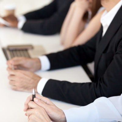 Hands of business people are on a desk at a meeting