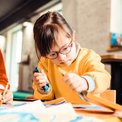 A young child does an activity at a table at school