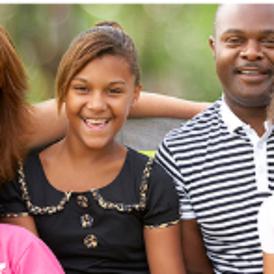 A family stands together outdoors