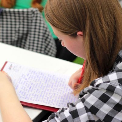 A young woman student writes on a piece of paper