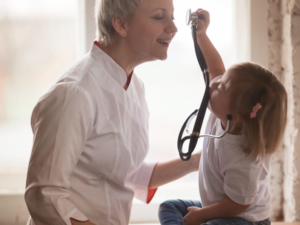 Mother and daughter playing with a stethoscope.