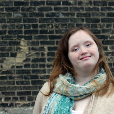 Girl in front of a black brick wall