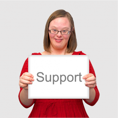 A woman in a red dress holds a sign saying support