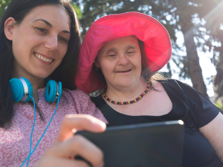 Two women look at a tablet computer